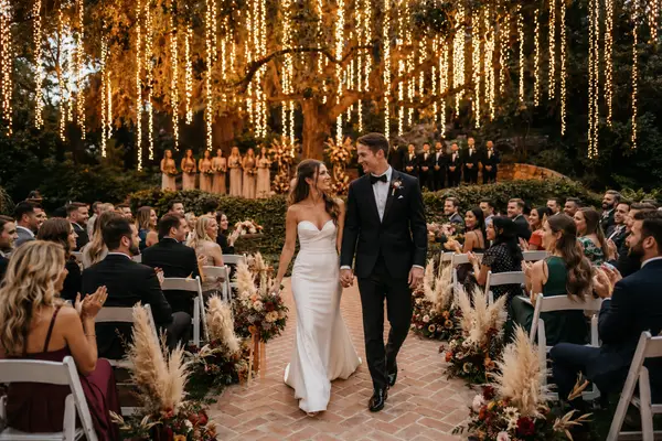 Couple walking up the aisle under string lights at Calamigos Ranch, a Malibu wedding venue